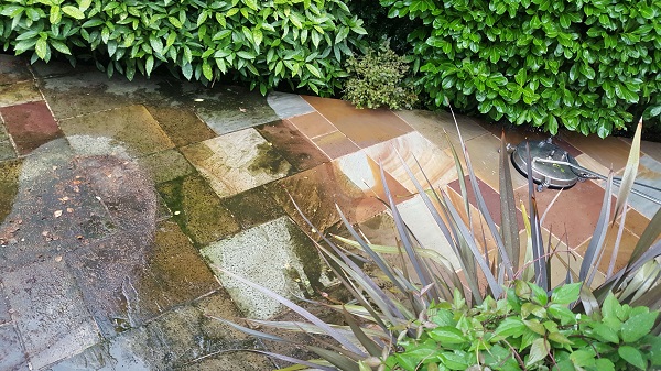 image of an Indian stone patio mid clean with half still dirty