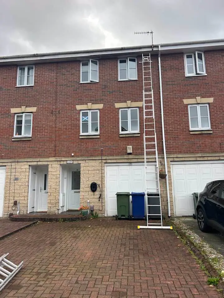 Renfrewshire gutter services cleaning gutters on a 3 storey town house with ladders
